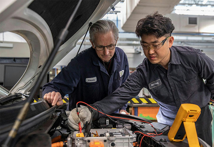 Student learning auto repair in a garage setting
